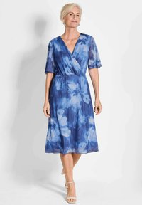 Blaues florales Wickelkleid mit kurzen Ärmeln, knielangem Saum und einer weichen, fließenden Textur. Verfügt über einen tiefen V-Ausschnitt und eine taillierte Taille.