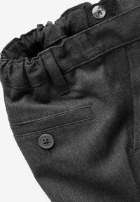 Pantalon gris foncé avec ceinture élastique, poche arrière boutonnée, et détail boucle de ceinture en tissu sur fond blanc.