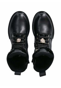 Stivaletti neri in pelle con lacci anteriori, dettagli metallici decorativi e una texture liscia. Presentano una linguetta sul retro.
