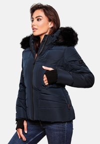 Navy blue puffer jacket with a faux fur hood, zippered pockets, ribbed cuffs, and quilted design, featured on a model against a plain background.