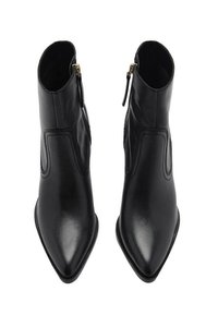 Botas de cuero negro hasta el tobillo con puntera afilada y cremallera lateral, que presentan una textura suave y detalles de costura mínimos.