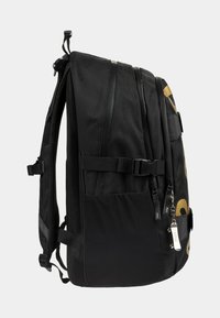 Zaino nero in materiale mesh e tessile, con più scomparti, spallacci regolabili e un logo dorato di lato.