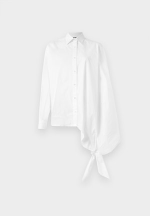 Camicia bianca a maniche lunghe con bottoni, dotata di una manica asimmetrica oversize arricciata legata al polso sul lato destro.