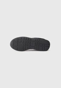 Zwarte sportieve schoenzool met textuur rubber grip. Kenmerkt zich door horizontale en verticale traction patronen en een lichte boogontwerp.