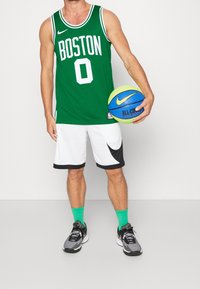 Zelený basketbalový dres s nápisem "BOSTON" a číslem "0" v bílé barvě. Doplněno bílými šortkami s černými akcenty. Zahrnut basketbal Nike a boty.