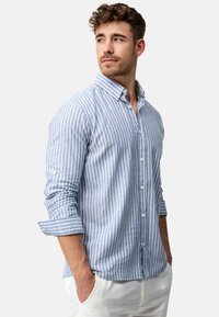 Gestreepte blauwe en witte button-up shirt van katoen, lange mouwen met opgerolde manchet, en een klassiek kraagontwerp.