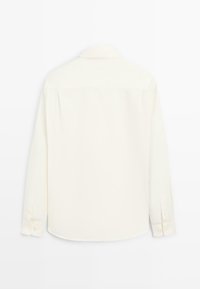 Camicia a maniche lunghe di colore bianco sporco, realizzata in tessuto liscio, con colletto classico, polsini con bottoni e un design dritto sul retro.
