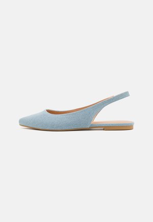 Lichtblauwe denim slingback platte schoen met puntige neus en tan zool op een effen witte achtergrond.