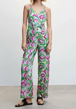 Kombinezon w kwiaty w zielone, różowe i białe wzory. Posiada dekolt w serek, cienkie ramiączka i szerokie nogawki. Noszony z czarnymi sandałami.