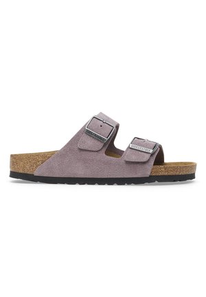 Lila Veloursleder-Birkenstock-Sandale mit zwei verstellbaren Schnallenriemen, konturiertem Korkfußbett und schwarzer, strukturierter Sohle.
