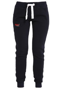 Mörkblå sweatshirtbyxor med vit dragsko, ribbade muddar och sidofickor; har en liten röd broderad logotyp på vänster lår.