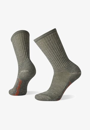 Graue gerippte Socken mit einer strukturierten Oberfläche, verstärkter Ferse und Zehenpartie sowie einem leuchtend orangefarbenen Akzent an der Unterseite.
