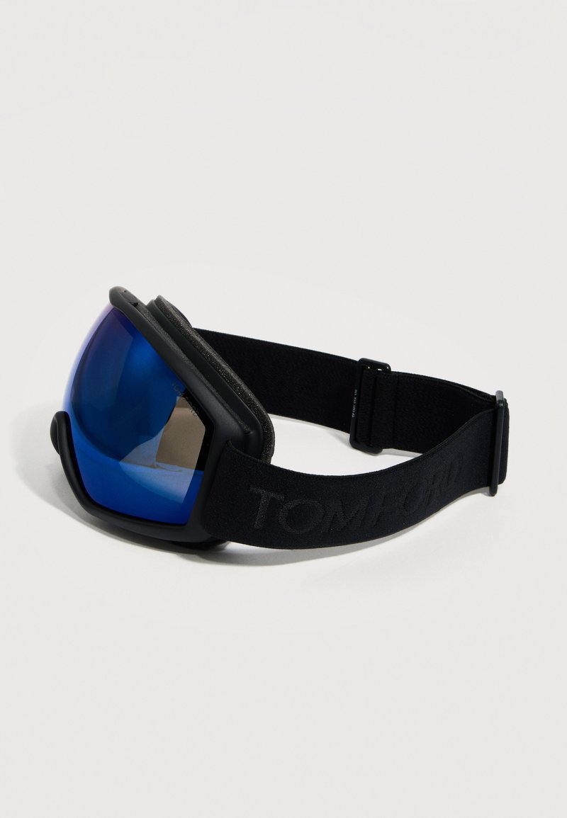 Lunettes de ski noires avec sangle réglable et verres courbés réfléchissants bleus, conçues pour la protection et le confort lors des sports d'hiver.