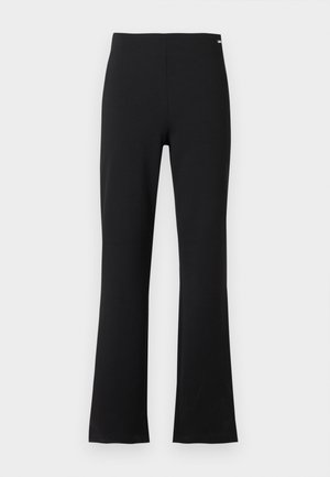 Pantalon noir à taille haute, coupe droite avec légère évasement au bas, présenté sur un fond gris clair uni.