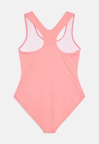 Maillot de bain une pièce à dos nageur en corail uni. Tissu lisse avec doublure intérieure contrastante. Présente une jambe haute et une couverture arrière minimale.