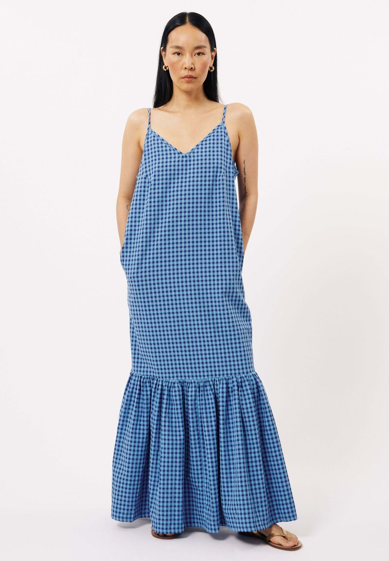 Robe maxi à motif vichy bleu et noir avec un corsage ajusté, un décolleté en V, des bretelles fines et un ourlet volanté. Le tissu semble léger et fluide.