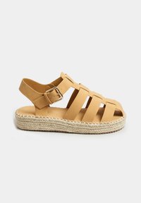 Sandalo in pelle marrone con più fascette, design open toe, fibbia regolabile alla caviglia e suola in giute intrecciato. Soletta piatta con dettagli cuciti.