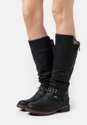 Black leather knee-high boots with a slouchy design, featuring a side zipper, studded ankle strap, and a textured finish.