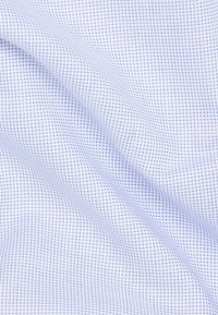 Tessuto di colore azzurro chiaro con una trama a griglia. Il materiale sembra essere tessuto, presentando piccole quadrature create da fili di contrasto.