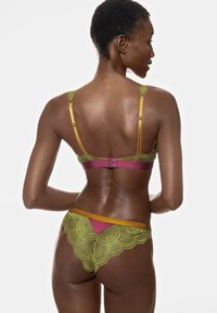 Spetsunderkläder i ett set med rosa bas, gröna spetstillägg och gula band. Bh:n har justerbara band och ett hänglås.