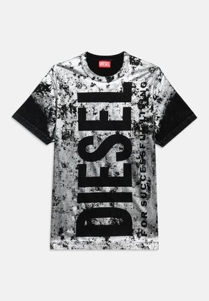 Mustvalge lühikeste varrukatega T-särk, millel on silmatorkav vertikaalne tekst "DIESEL" ja ees väiksem loosung "FOR SUCCESSFUL LIVING".