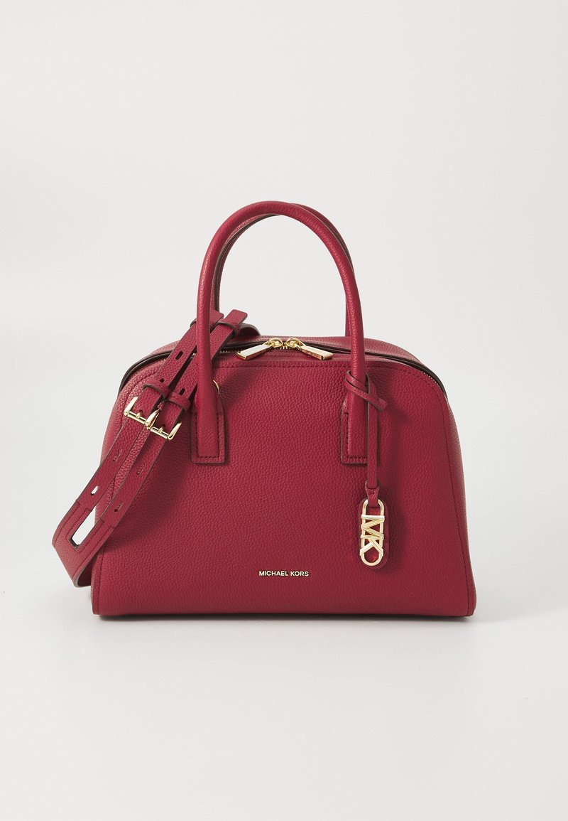 Sac à main en cuir rouge texturé avec deux poignées, une bandoulière ajustable, une fermeture éclair dorée et un petit logo de marque doré sur le devant.