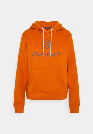 Pomarańczowa bluza z kapturem z przednią kieszenią, białymi troczkami i niebieskim logo „GANT” wyszytym na piersi.