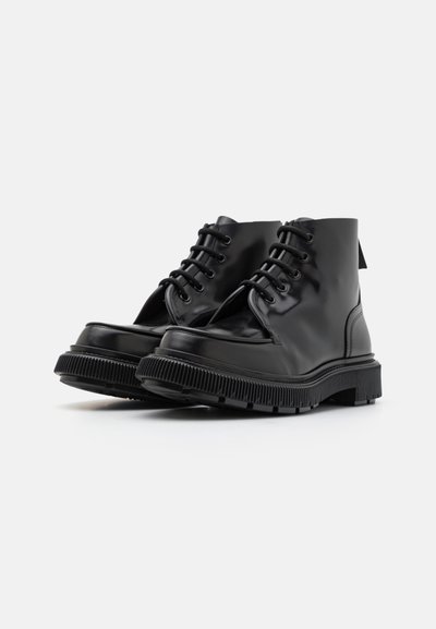 Botine din piele neagră, cu vârful rotund, sistem de închidere cu șireturi și talpă din cauciuc texturată. Finisaj neted cu o strălucire subtilă și fără embellishments suplimentare.