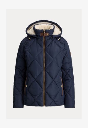 Tengerész kék, steppelt pufi dzseki kapucnival, krémszínű műszőrme béléssel. Elől cipzárral, fűzős díszítésekkel és kontrasztos barna díszítéssel rendelkezik.