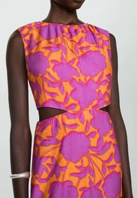 Bloemen crop top met een levendig oranje en roze ontwerp, van een gestructureerde stof en met uitgesneden details op de taille.