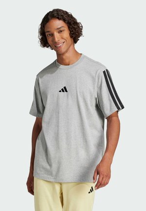 Grijze katoenen t-shirt met korte mouwen, ronde hals en drie zwarte strepen op beide schouders. Zwart logo op de borst.