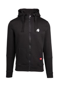 Felpa nera con zip, cappuccio, tasche frontali e logo di un gorilla bianco sul petto. Presenta polsini e orlo inferiore a costine. La trama del tessuto è liscia.