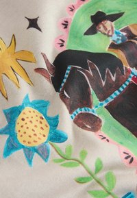 Színes mintázattal ellátott anyag, amelyen egy barna ló, kék és sárga virágmotívumok, valamint egy cowgirl látható zöld háttérben.