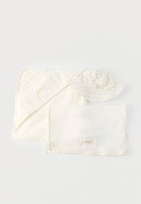 Μαλακή μπουκλέ πετσέτα μωρού με κουκούλα σε κρεμ απόχρωση, αντίστοιχη κουβέρτα και καπέλο με φαρδύ γείσο για τον ήλιο, με διακριτικό μπεζ κείμενο και κεντημένο λογότυπο.