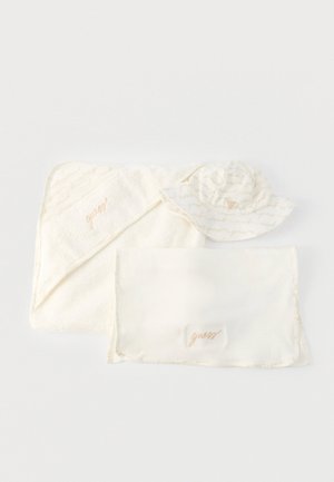 Mīksta krēmkrāsas kapuce bērnu dvielis, atbilstoša sega un plata malu saules cepure ar smalku bēša skriptu un izšūtu logo.