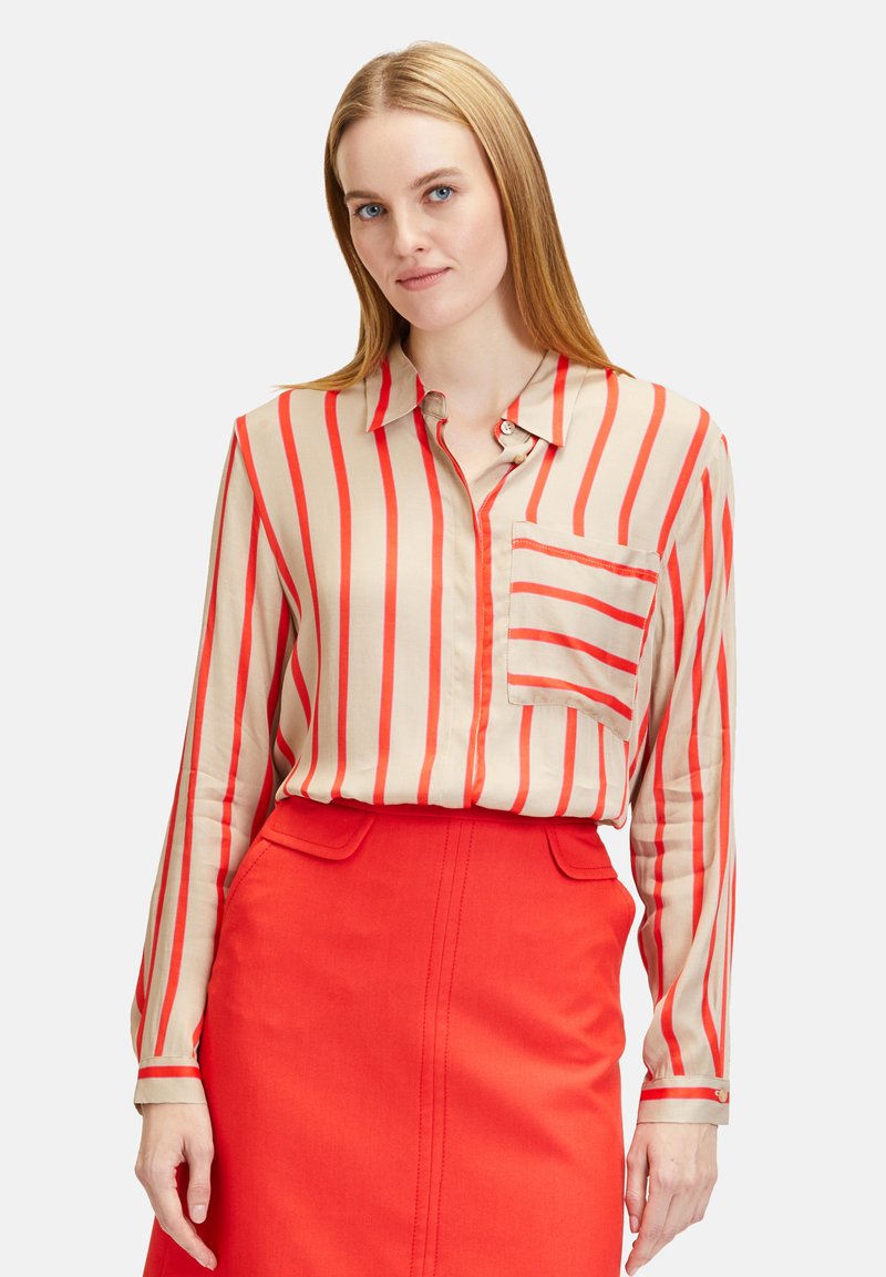 Beige blouse with red vertical stripes, long sleeves, collar, and chest pocket, paired with a bright red skirt. Smooth texture.