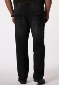 Pantalones de mezclilla negros con un corte relajado, que presentan dos bolsillos traseros y un acabado texturizado. Cintura elástica para mayor comodidad.
