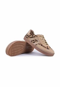 Baskets basses beiges avec des panneaux imprimé léopard, fermeture à lacets et semelles en caoutchouc marron, une chaussure reposant sur l’autre montrant le motif de la semelle.