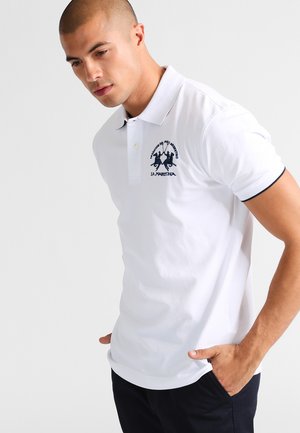 Polo bianco in cotone, con logo ricamato navy sul petto e accenti navy a contrasto sul colletto e sulle maniche.
