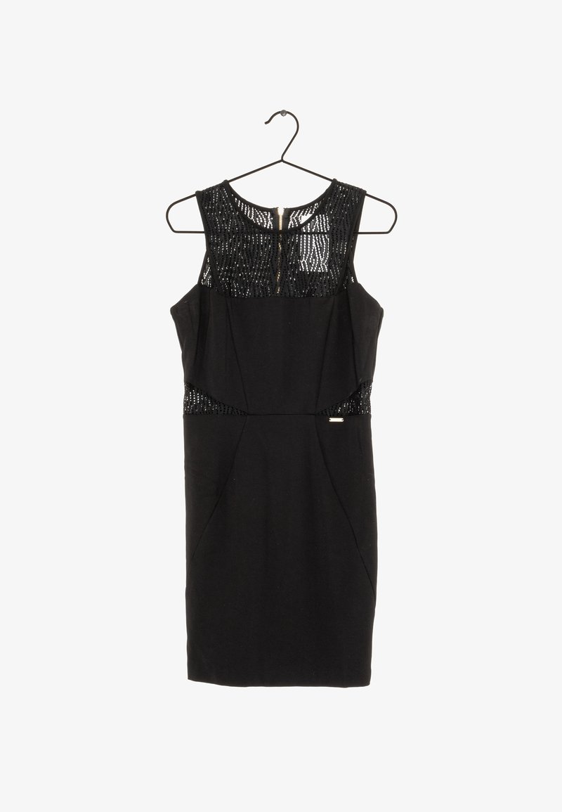 Robe de cocktail noire sans manches avec un motif en mesh au niveau du col et de la taille, suspendue sur un cintre métallique sur fond blanc.