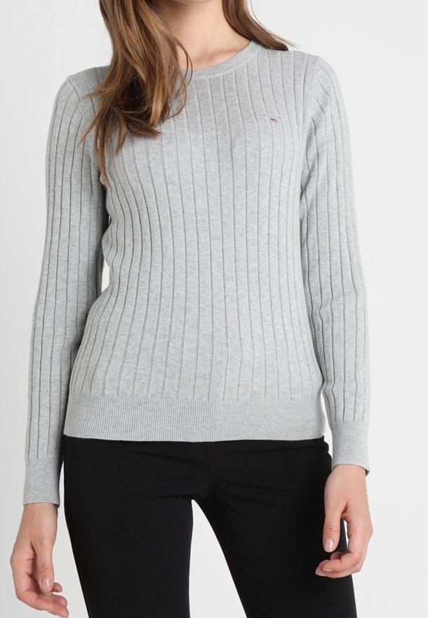 Maglione a costine grigio chiaro con maniche lunghe e scollo a giro. Presenta una forma aderente e un tessuto testurizzato. Nessun motivo o accento visibile.