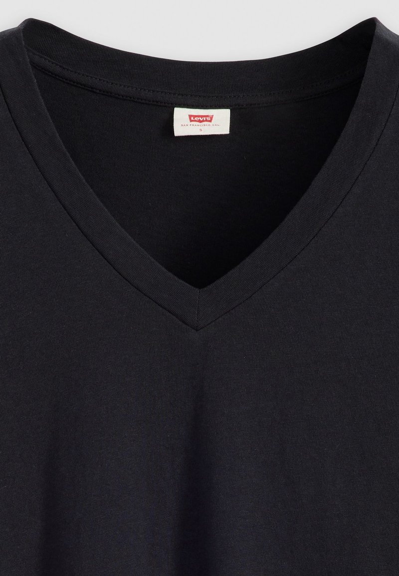 Czarny T-shirt z dekoltem w serek, wykonany z bawełny. Posiada miękką teksturę i przeszywaną linię dekoltu. Logo Levi's widoczne na środku dekoltu.