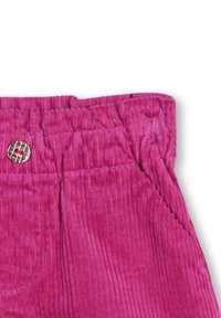 Pantalons en velours côtelé rose avec des côtes verticales, présentant une taille élastique et un petit accent de bouton métallique près du haut.