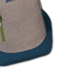 Sac à dos en tissu gris avec une fermeture éclair verte, un panneau inférieur bleu et une poche latérale en mesh. Il présente un fond arrondi et un logo en relief à l'avant.