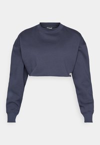 Kuttet marineblå genser laget av bomull, med rund hals, lange ermer, og teksturert stoff med en subtil logoetikett på kanten.