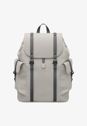 Rucsac gri deschis cu bretele gri închis, închidere cu clapetă, buzunare laterale și o suprafață texturată. Prezintă un logo subtil al brandului în partea de jos.