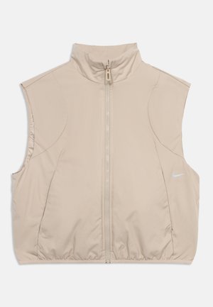 Beige ärmellose Weste mit Frontreißverschluss, hohem Kragen, elastischem Saum und kleinem weißen Nike-Logo auf der linken Seite.