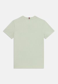 Hellgrünes Baumwoll-T-Shirt, kurzärmlig, Rundhals, schlichtes Design, mit einem kleinen rot-weiß-blauen Streifen am hinteren Kragen.