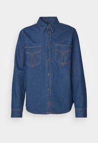 Camicia in denim blu scuro con colletto a punta, chiusura frontale con bottoni, due tasche sul petto e dettagli di cucitura arancione a contrasto.