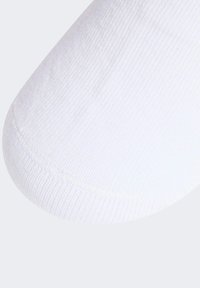 Witte sok met een geribbelde textuur en een gladde afwerking, met een ronde teen en subtiele naaddetails.